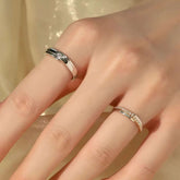 Hand wearing bezel diamond band on index and pavé orbit band on ring finger